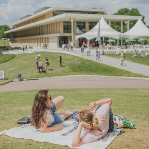Two students sunbathing in front of the university of Essex